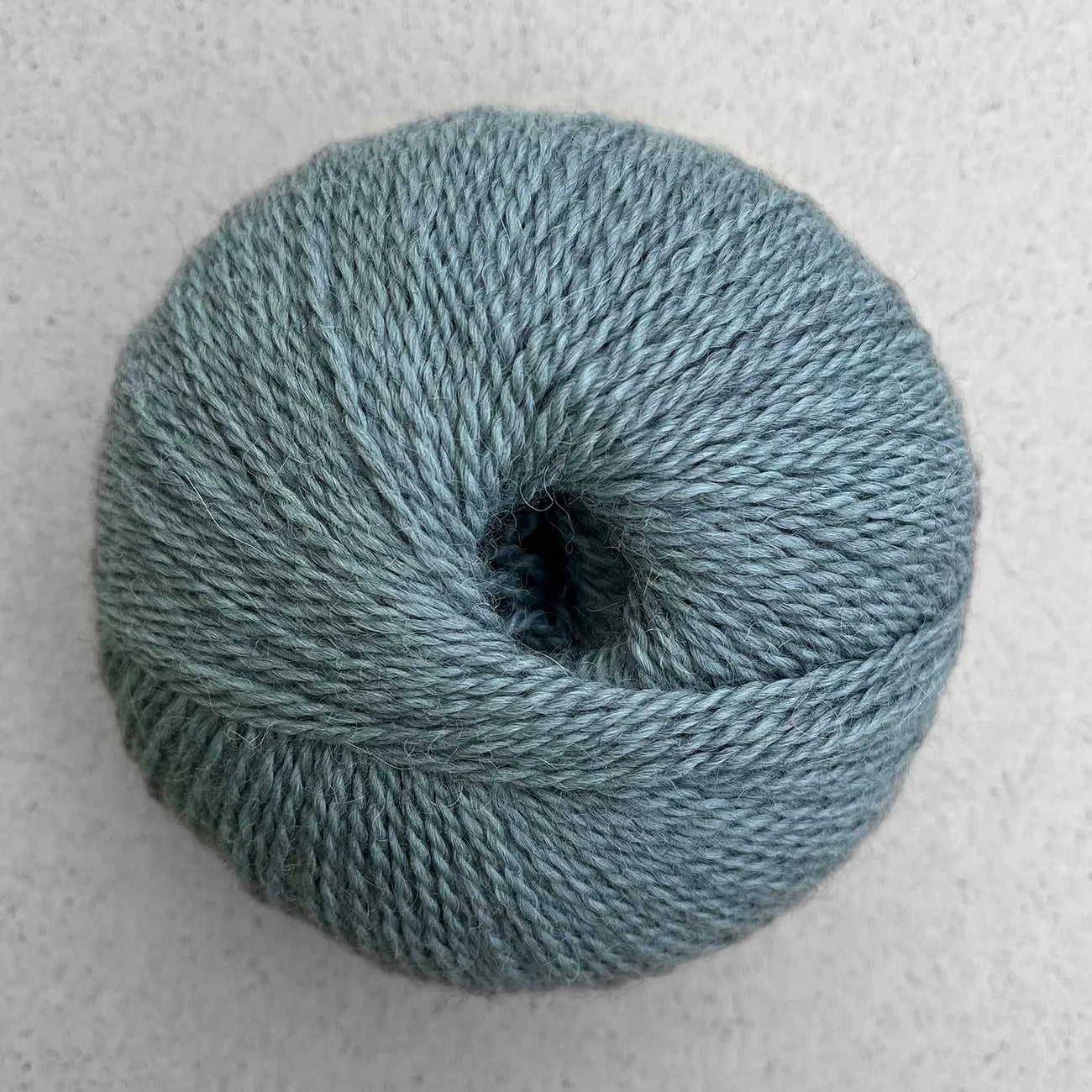Ball of heathered light teal Pascuali Balayage yarn.