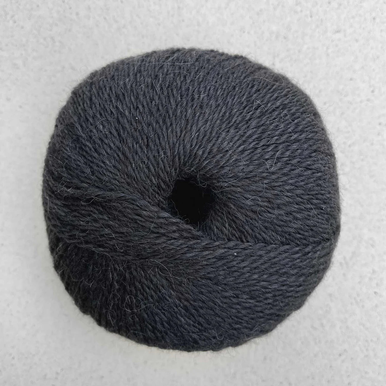 Ball of charcoal gray Pascuali Balayage yarn.