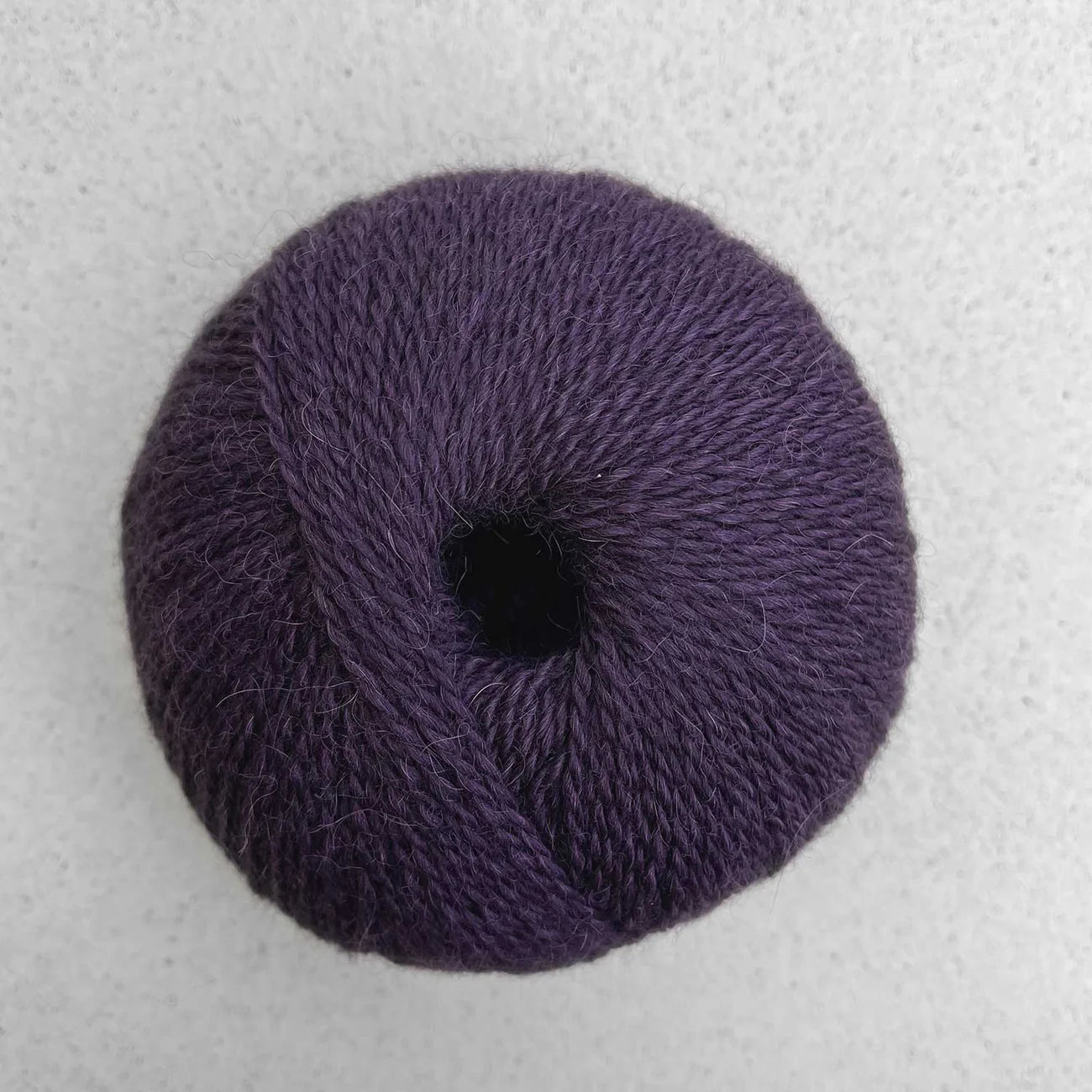 Ball of dark purple Pascuali Balayage yarn.