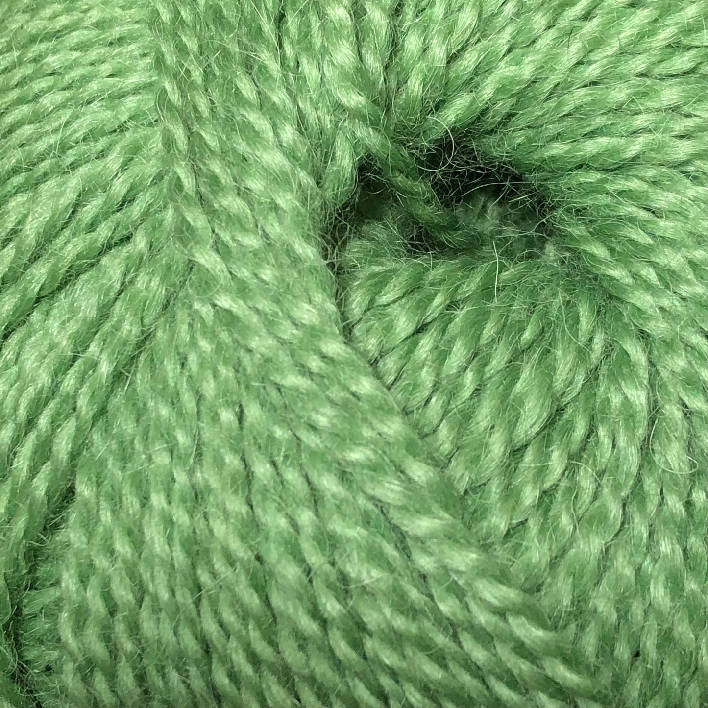 Close up on a ball of bright green Jo Sharp Alpaca Kid Lustre yarn.