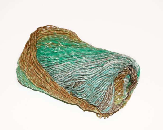 A skein of self-striping yarn in greens and yellow ochre.