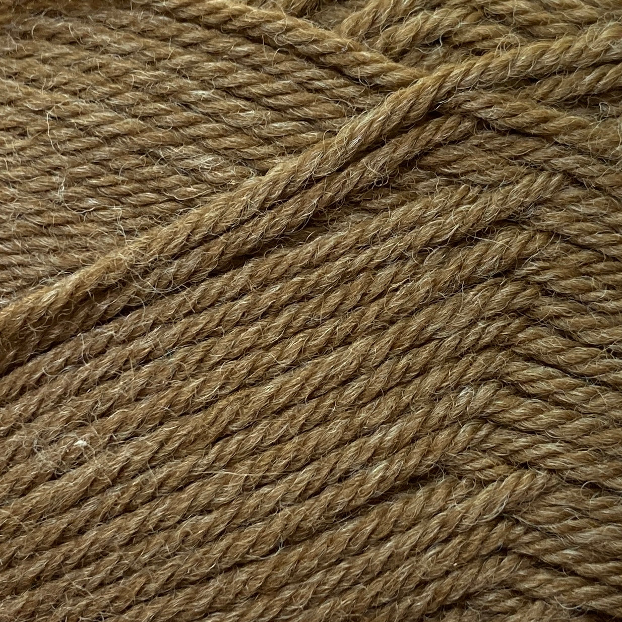 Close up on an olive green ball of Jo Sharp Classic Wool DK yarn.