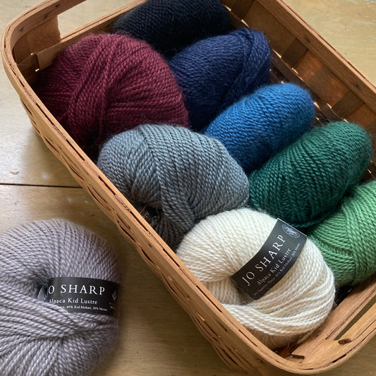 Close up on a basket of colorful balls of Jo Sharp Alpaca Kid Lustre yarn.