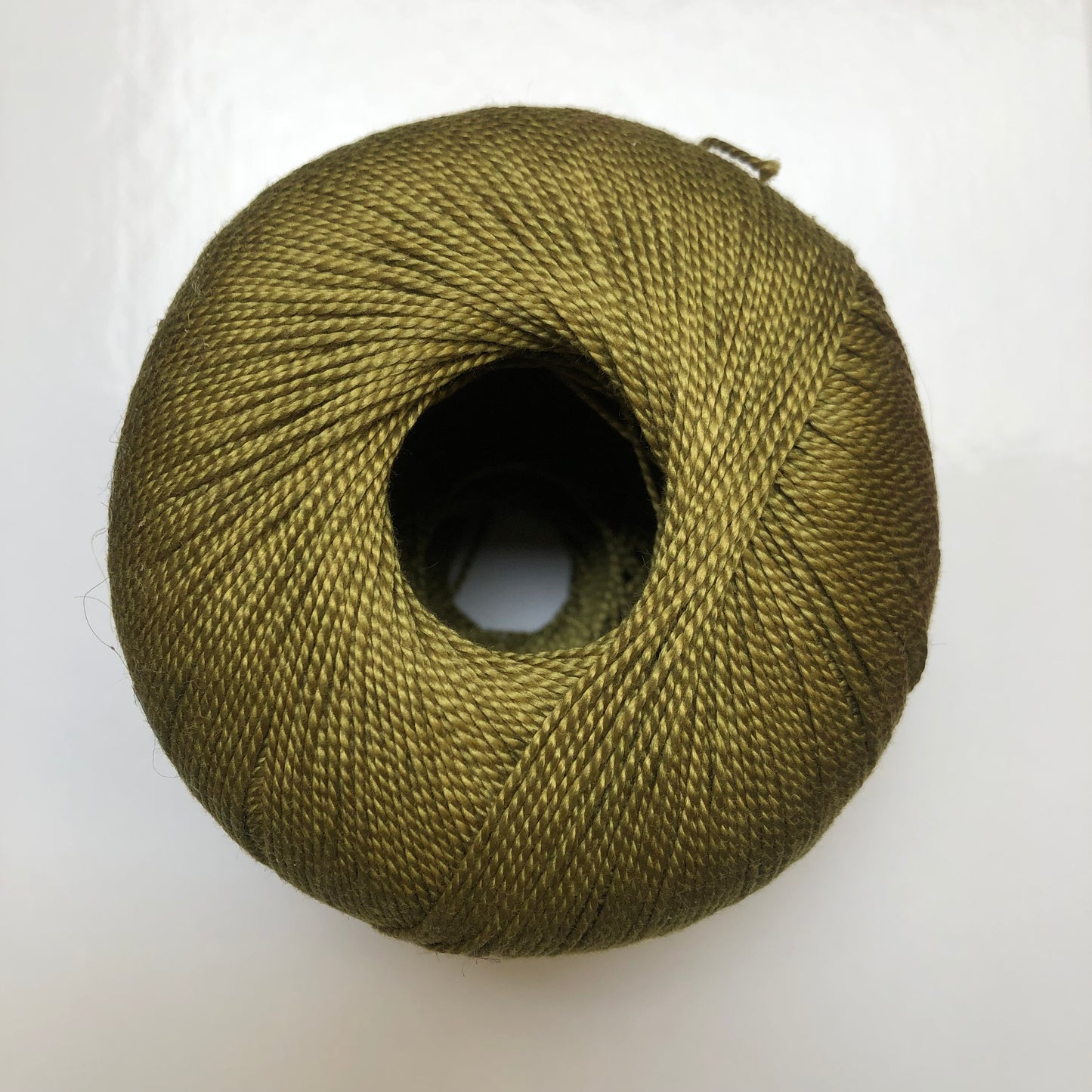 Ball of olive green Isager Bomuld yarn.