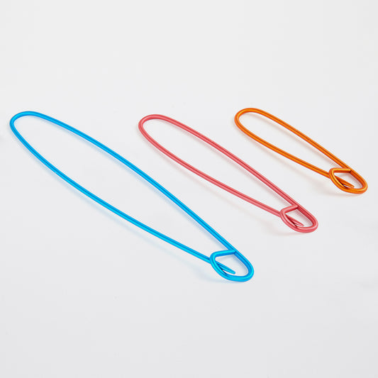 Three colorful aluminum stitch holders in different sizes.