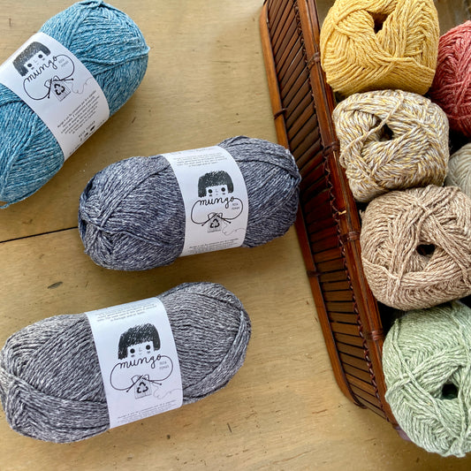 Basket of colorful Retrosaria Rosa Pomar Mungo yarn, displayed on a wooden surface at Hillsborough Yarn Shop