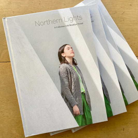 Stack of Northern Lights books on a wooden surface.