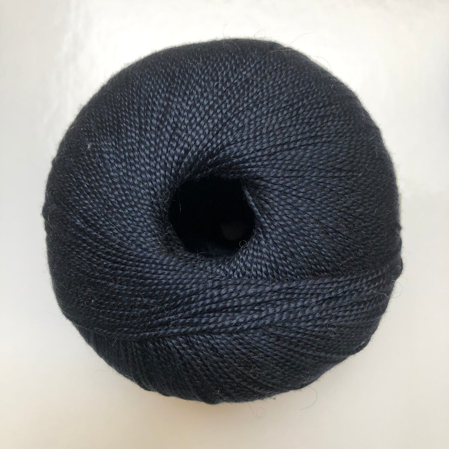 Ball of dark blue Isager Bomuld yarn.