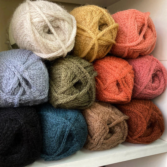 Close up on a cubby filled with colorful balls of Isager Alpaca 3 yarn.