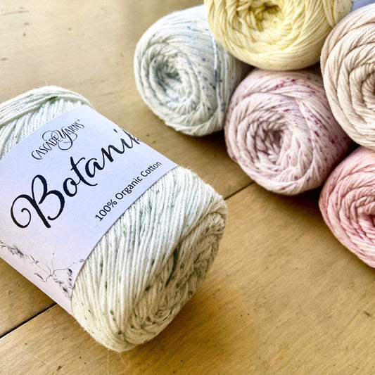 Pastel balls of Cascade Botanika lying on a wooden surface.