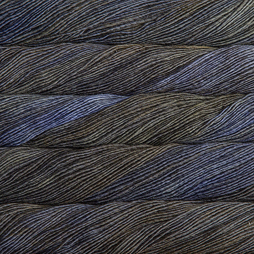Close up on variegated charcoal and lavender skeins of Malabrigo Lace yarn.