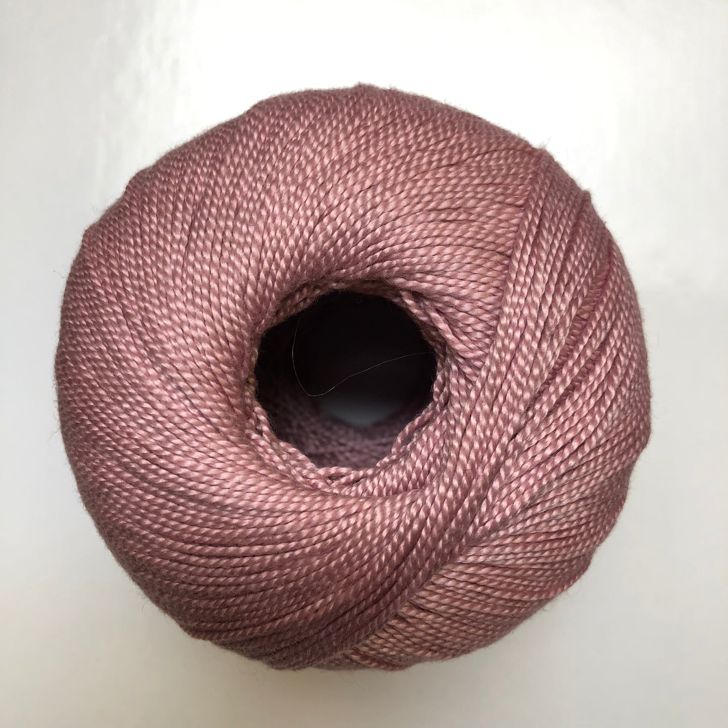 Ball of rose pink Isager Bomuld yarn.