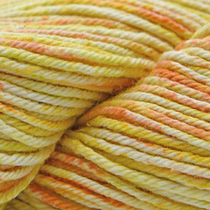 Close up on a speckled yellow, orange and cream skein of Cascade Nifty Cotton Splash yarn.