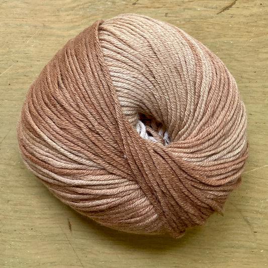 Ball of Katia Degrade yarn in shades of light brown.