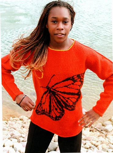 Image of young woman wearing a bright red sweater with a large black butterfly motif, knit using Armenian knitting method.
