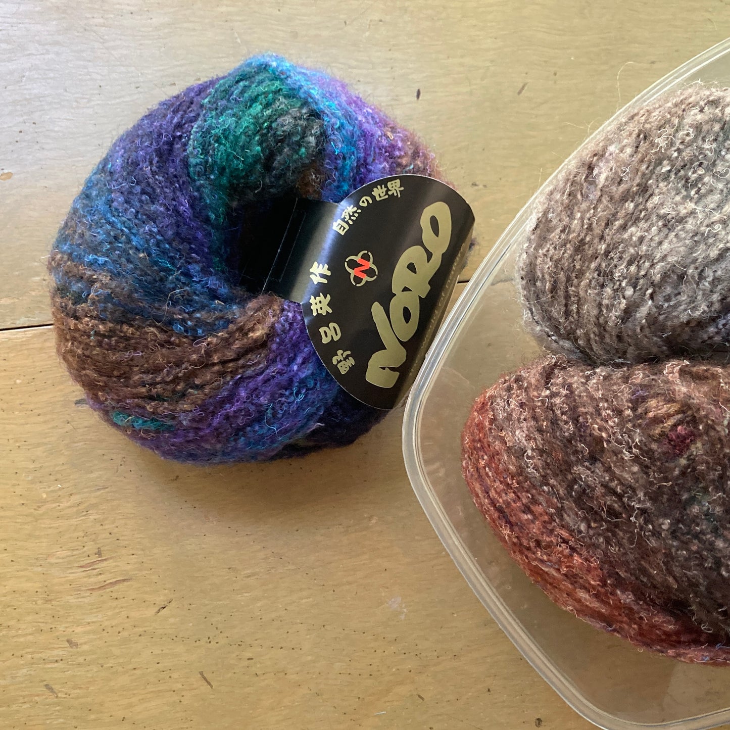 One ball of yarn with a bowl of yarn in the corner.