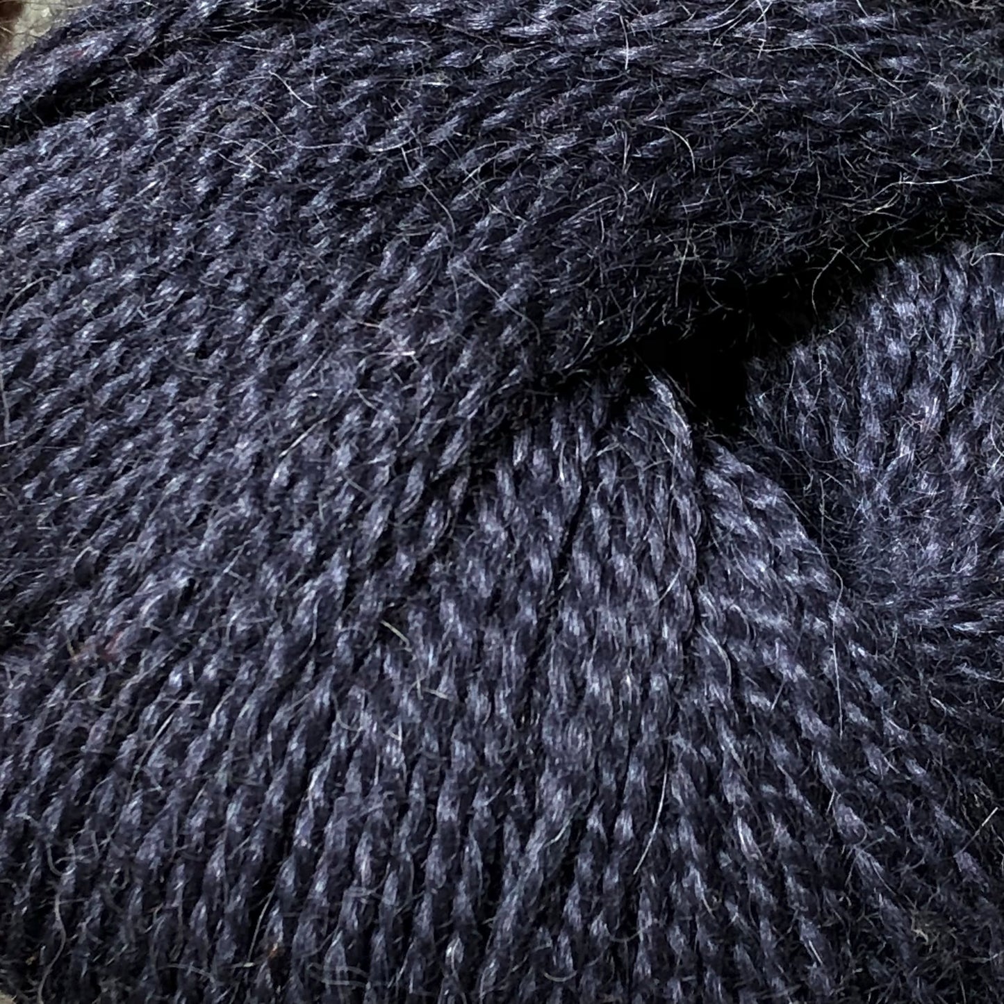 Close up on a ball of dark blue Jo Sharp Alpaca Kid Lustre yarn.