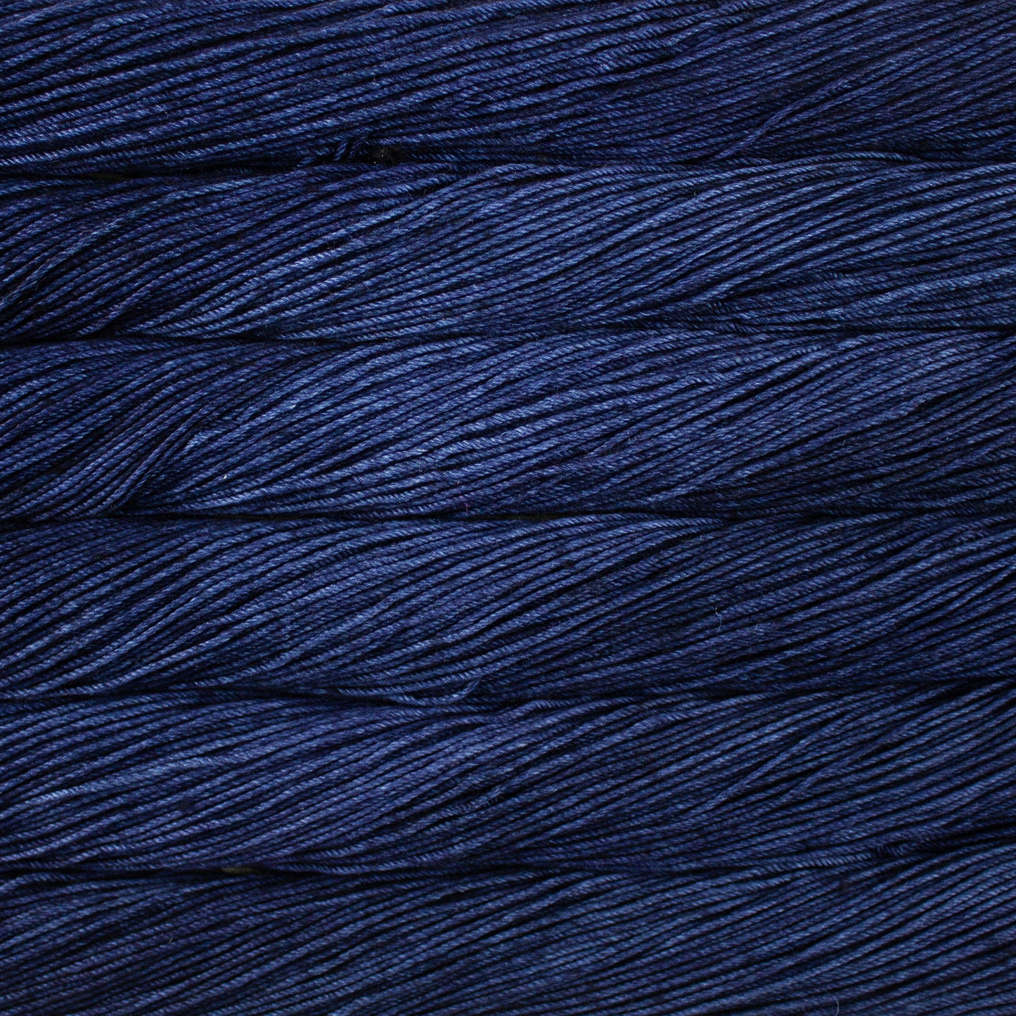 Skein of semisolid dark blue Malabrigo Caprino yarn.