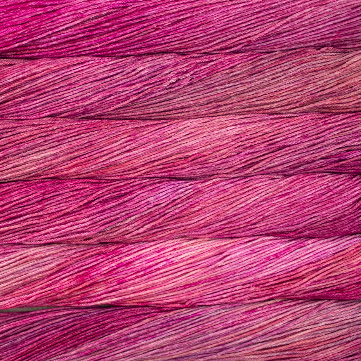 Skein of semisolid pink Malabrigo Caprino yarn.