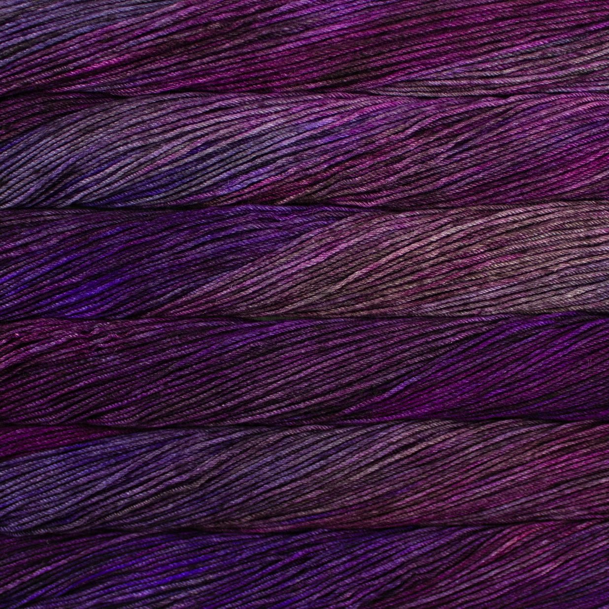 Skein of variegated purple and pink Malabrigo Caprino yarn.