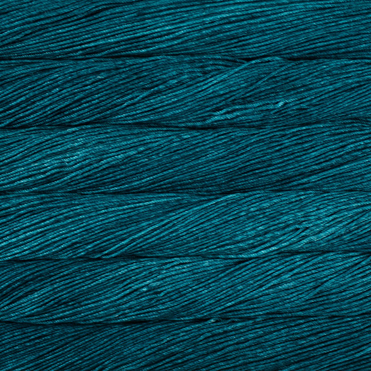 Skein of semisolid teal Malabrigo Caprino yarn.