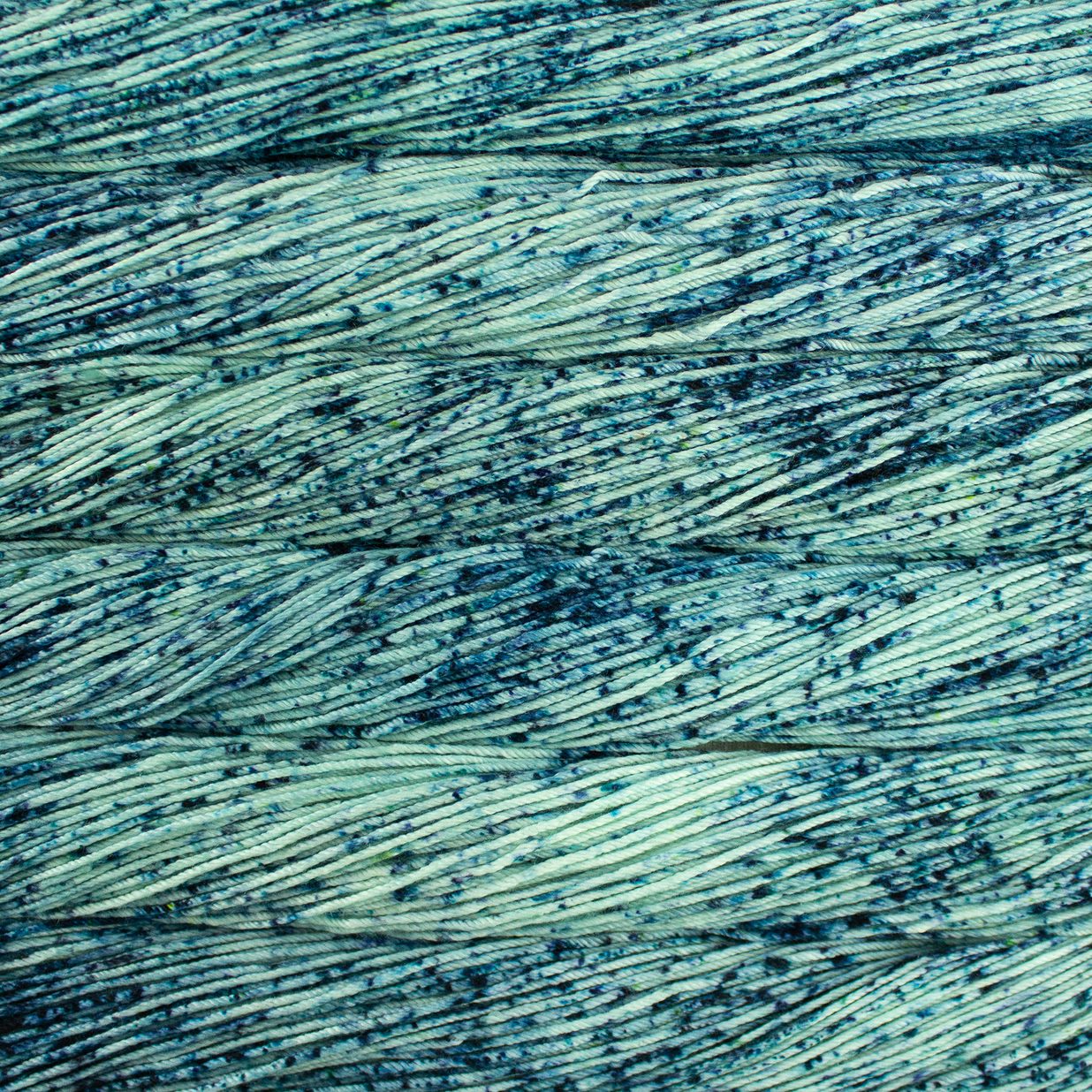 Skein of speckled teal Malabrigo Caprino yarn.
