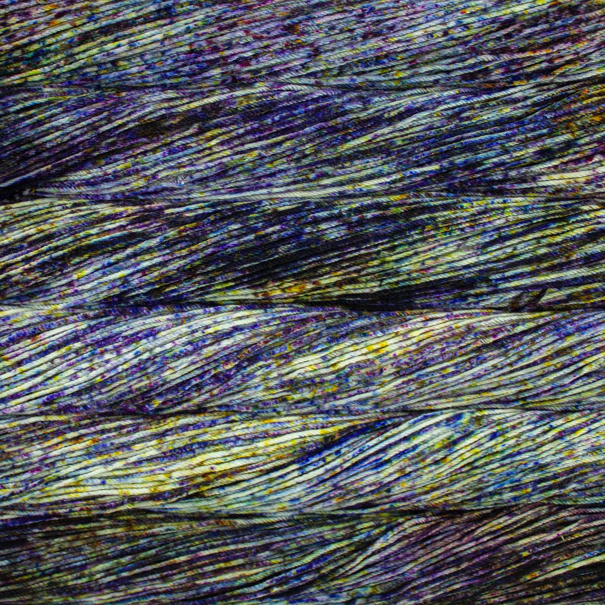 Skein of speckled blue, green, and yellow Malabrigo Caprino yarn.