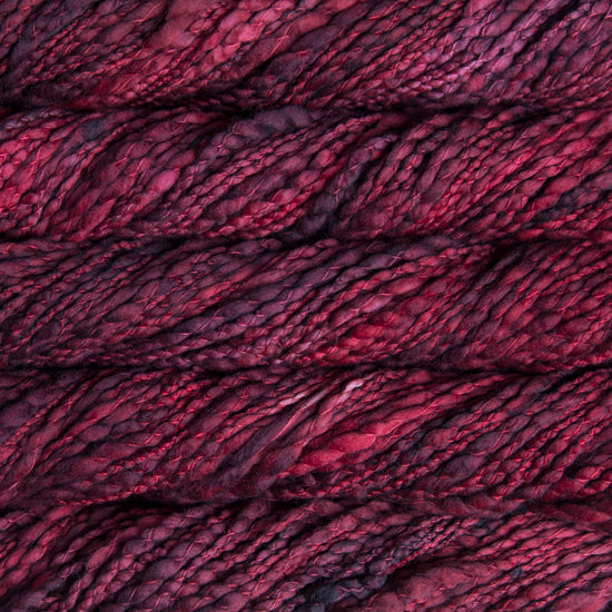 Skein of variegated red and burgundy Malabrigo Caracol yarn.