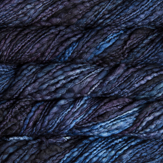 Skein of variegated dark purple and blue Malabrigo Caracol yarn.