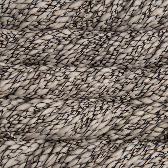 Skein of marled black and white Malabrigo Caracol yarn.