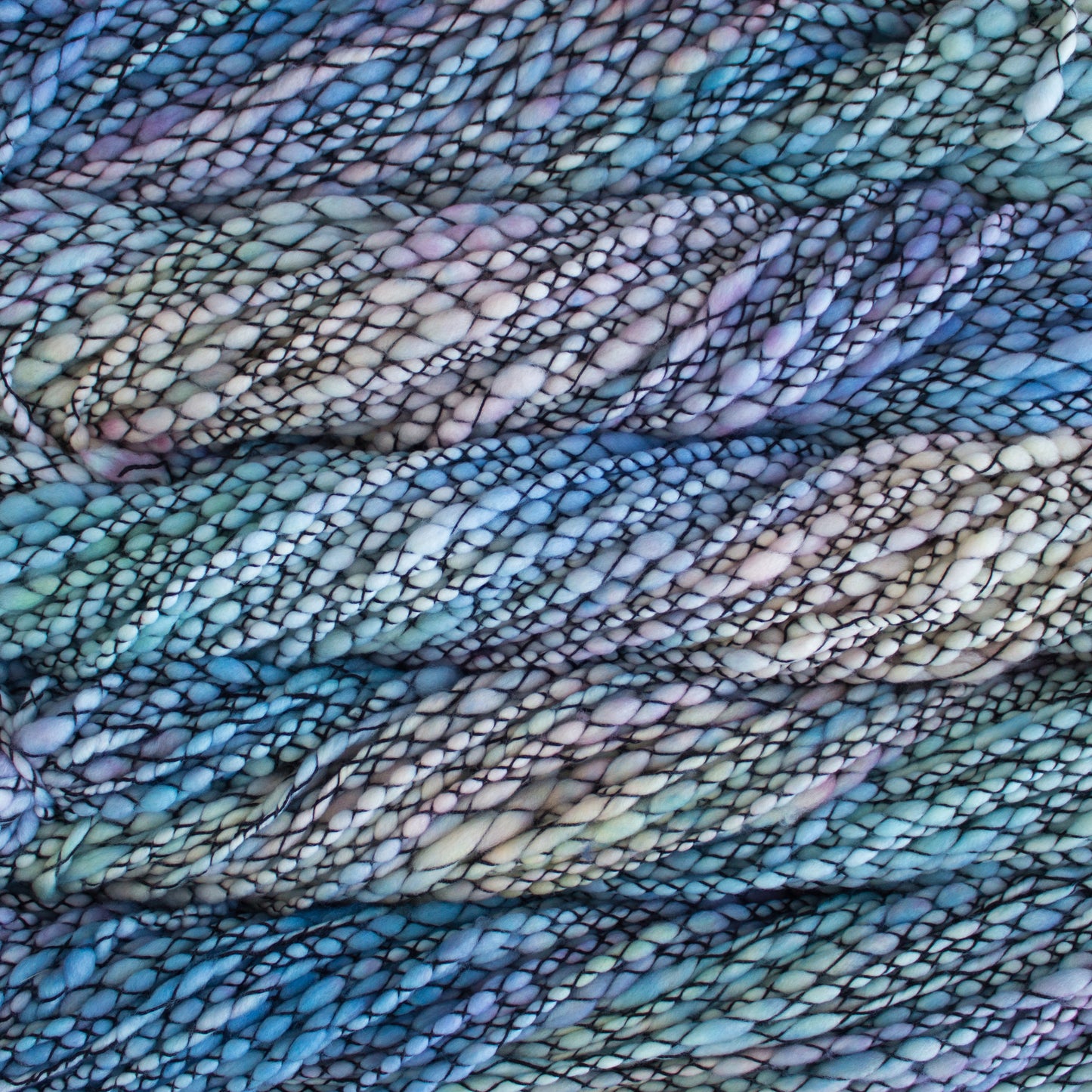Skein of variegated pastel blue and purple Malabrigo Caracol yarn.
