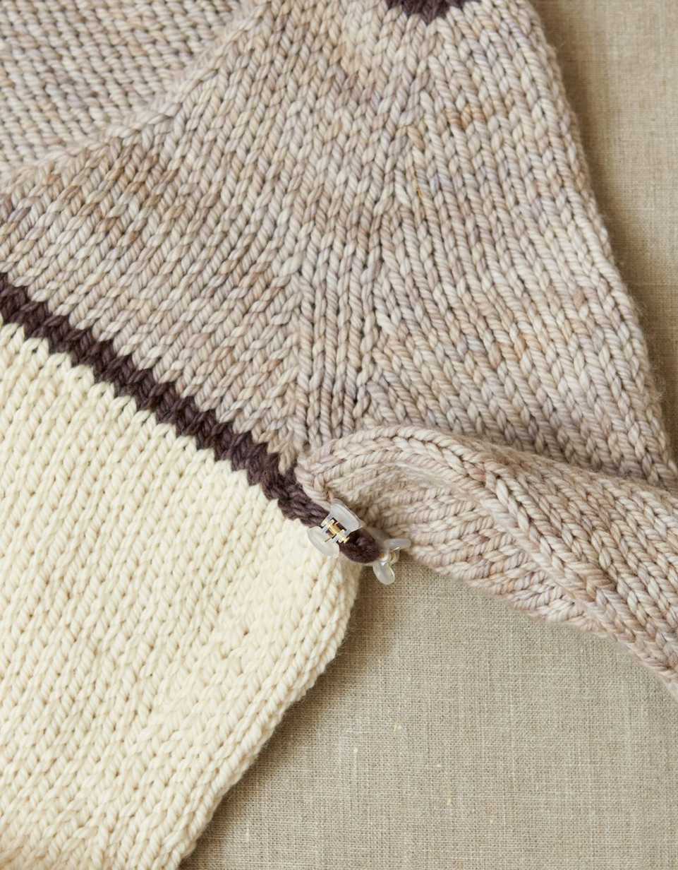 Close up on the armpit of a handknit sweater, held together by cocoknits claw clips.