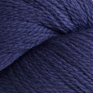 Close up on a dark blue skein of Cascade 220 Fingering yarn.