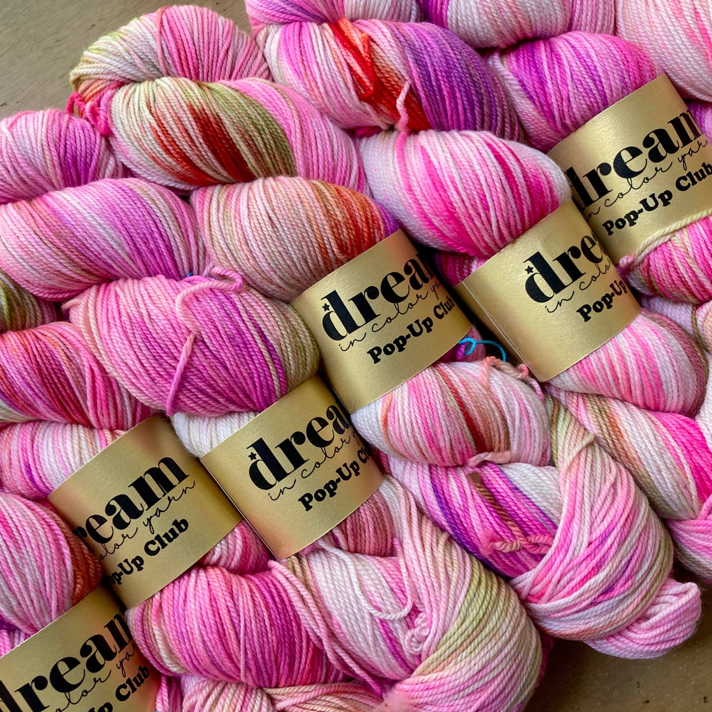 Variegated neon pink and cream skeins of Dream in Color Smooshy Cashmere yarn.