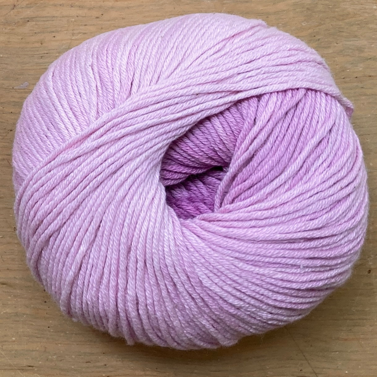Ball of Katia Degrade yarn in shades of light purple.