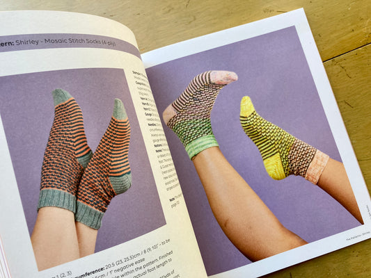 Pom Pom’s Ready Set Socks book lying open, showing photos of feet wearing colorful socks.