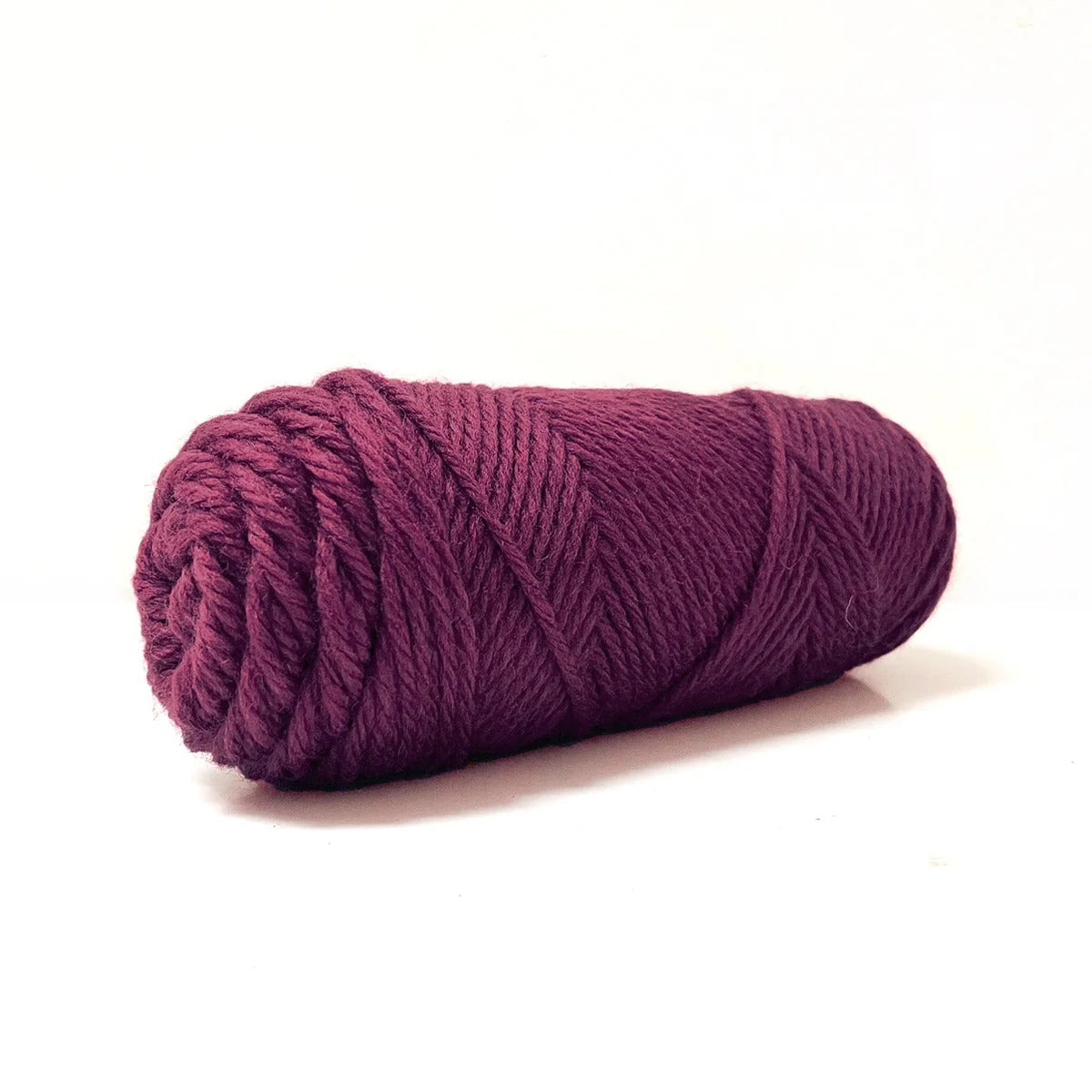 A skein of burgundy Kelbourne Woolens Germantown Bulky yarn.