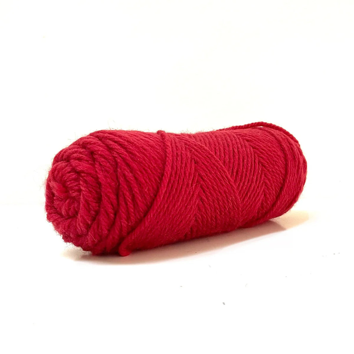 A skein of red Kelbourne Woolens Germantown Bulky yarn.