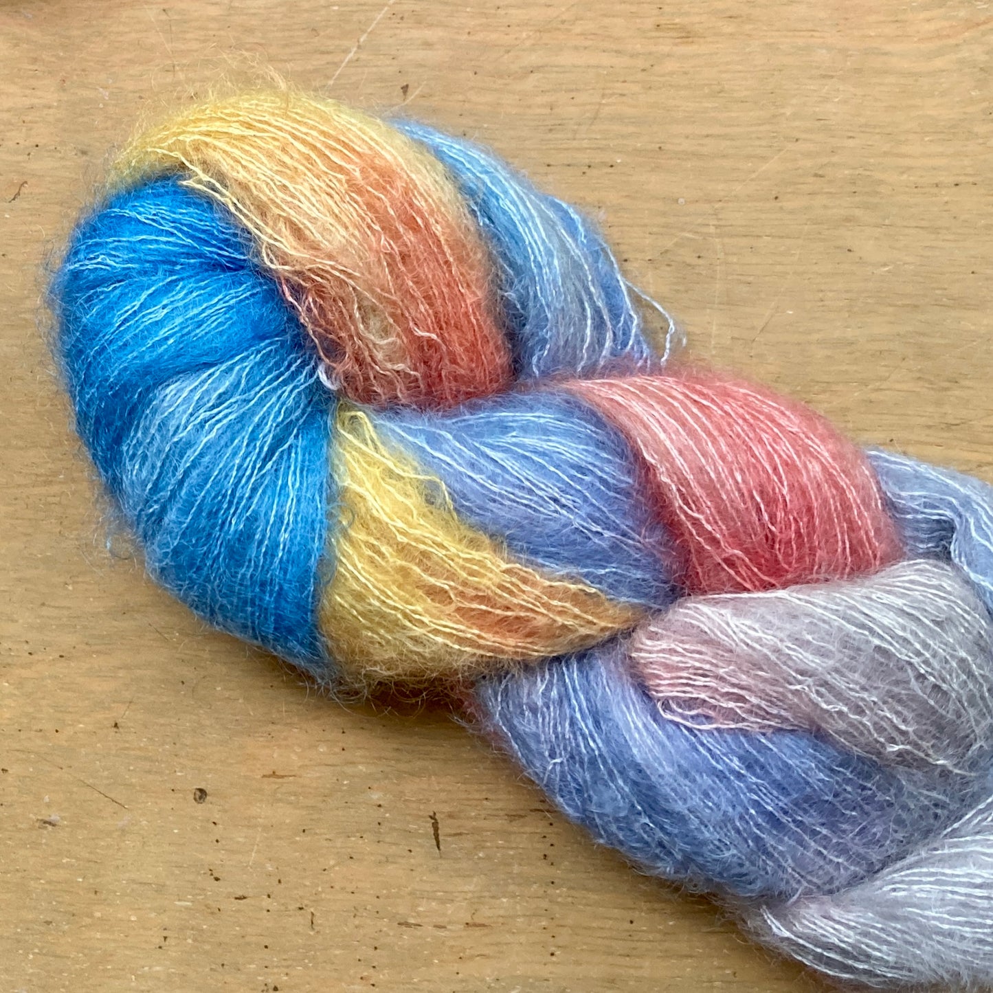 Variegated blue, yellow and coral skein of Hand Maiden Superkid Silk yarn, Arctic Sunrise colorway