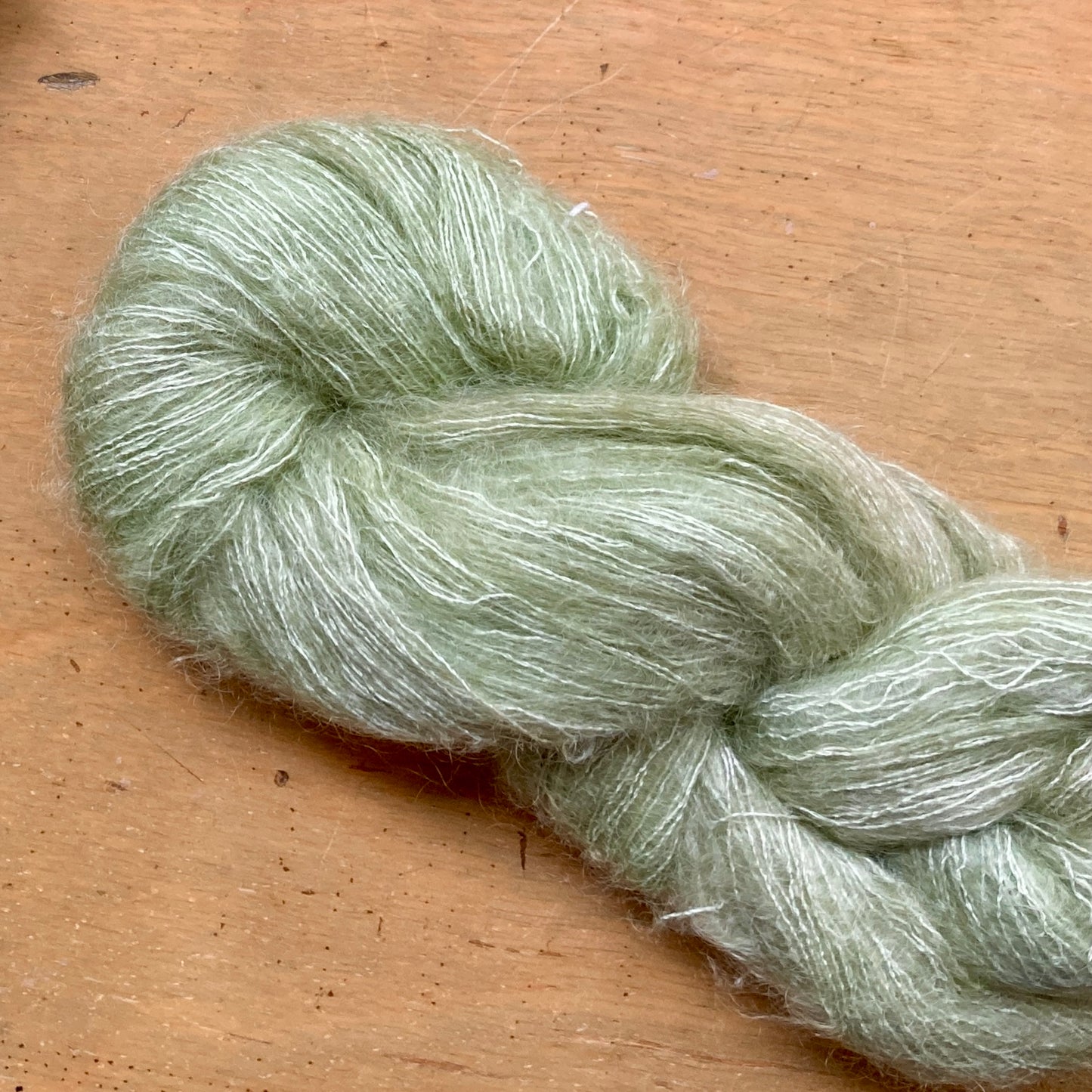 Sage eucalyptus green skein of Fleece Artist / Hand Maiden Superkid Silk yarn.