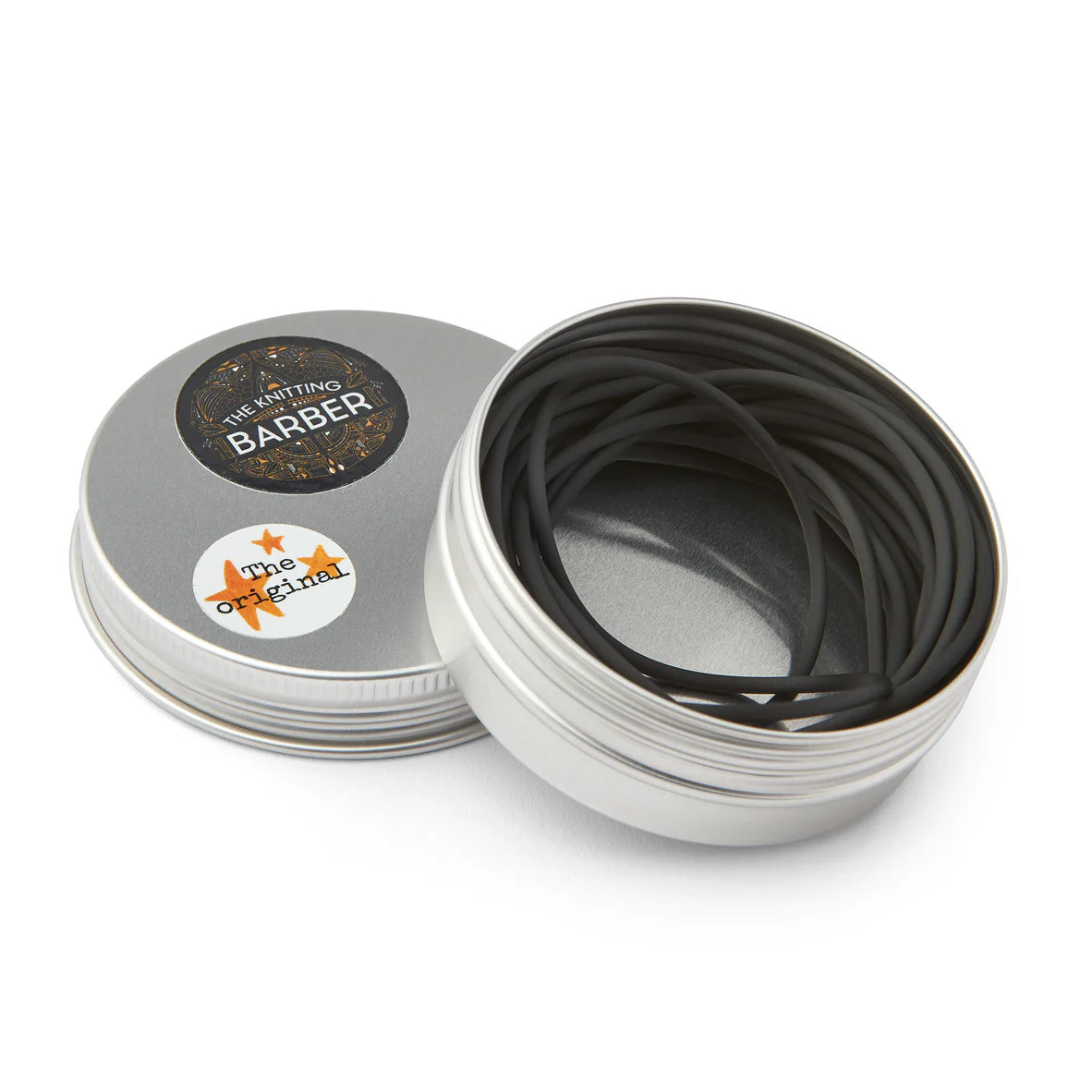 Round silver tin lying open beside its lid, showing black Knitting Barber Cords coiled inside.