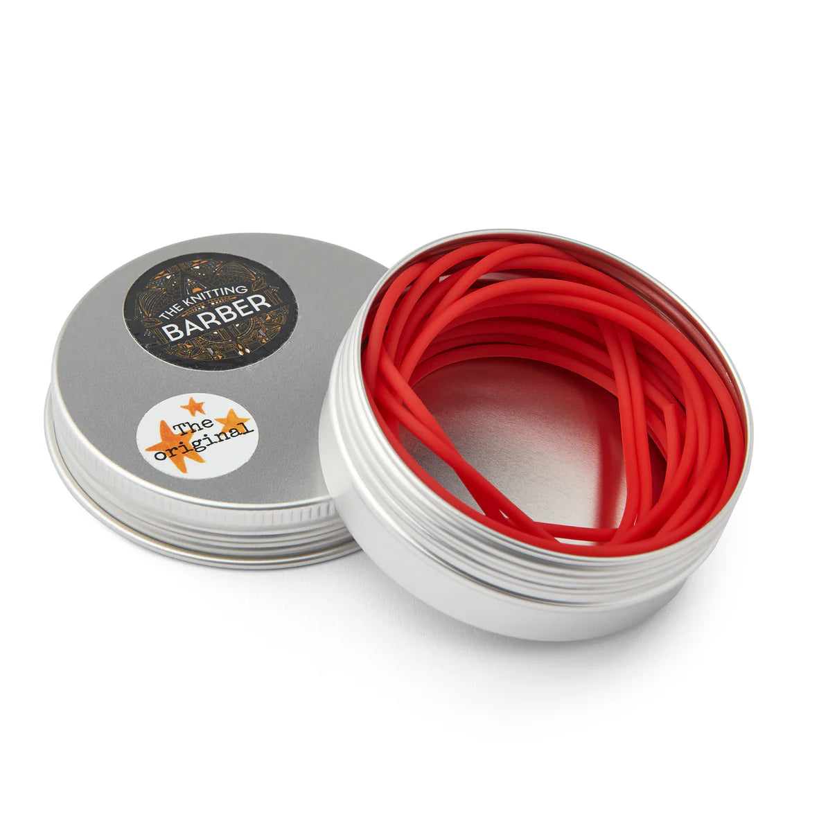 Round silver tin lying open beside its lid, showing red Knitting Barber Cords coiled inside.