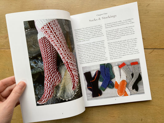 Paging through Knitting Around, by Elizabeth Zimmermann; the book lies open, showing photos of handknit socks.