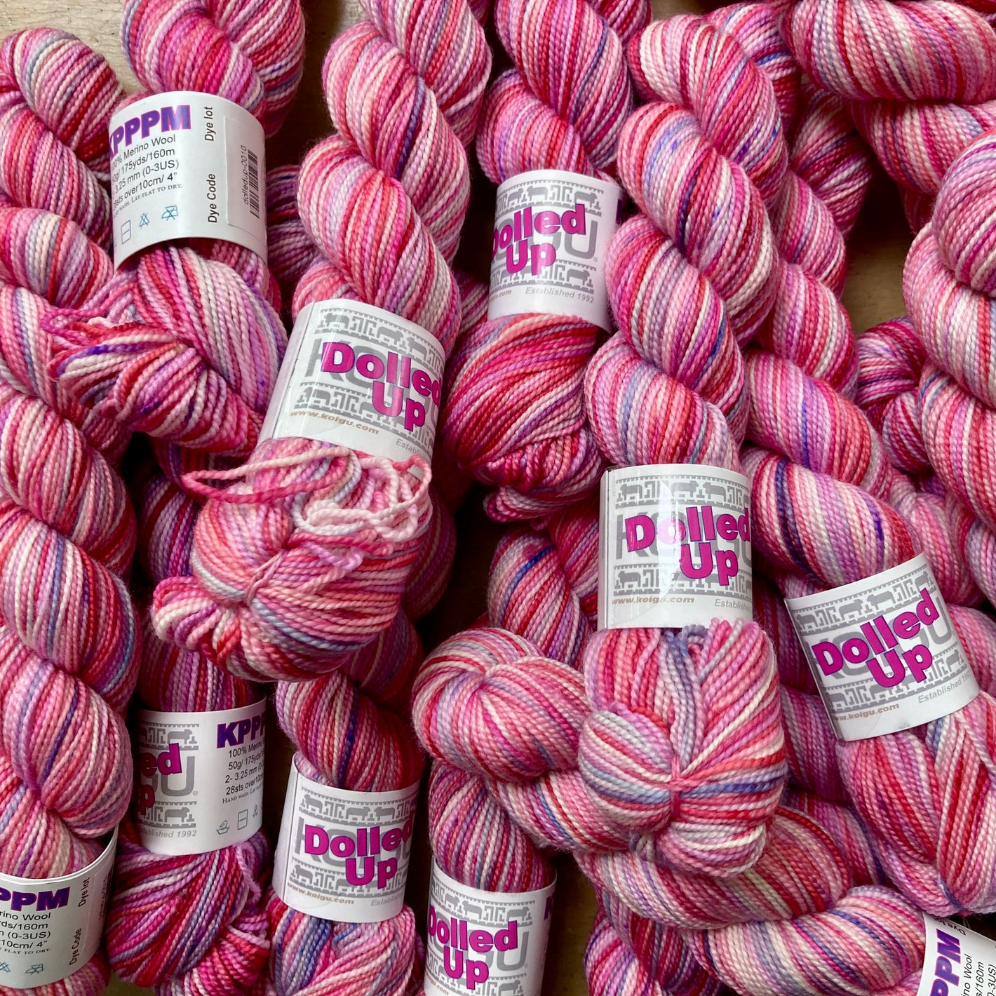 Magenta, light pink and purple variegated skeins of Koigu KPPPM yarn.