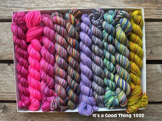 Rectangular package holding ten mini skeins of colorful hand dyed Koigu KPPPM yarn.