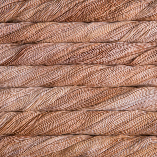 Close up on variegated beige skeins of Malabrigo Lace yarn.