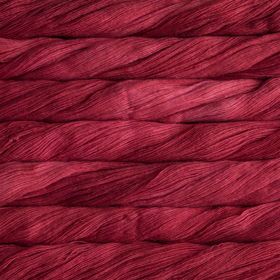 Close up on variegated red skeins of Malabrigo Lace yarn.
