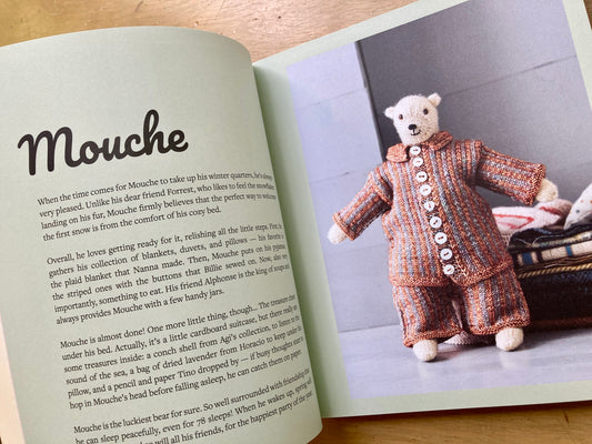 Cinthia Vallet’s Mouche & Friends book, lying open to show text and photos of handknit stuffed animals in intricate outfits.