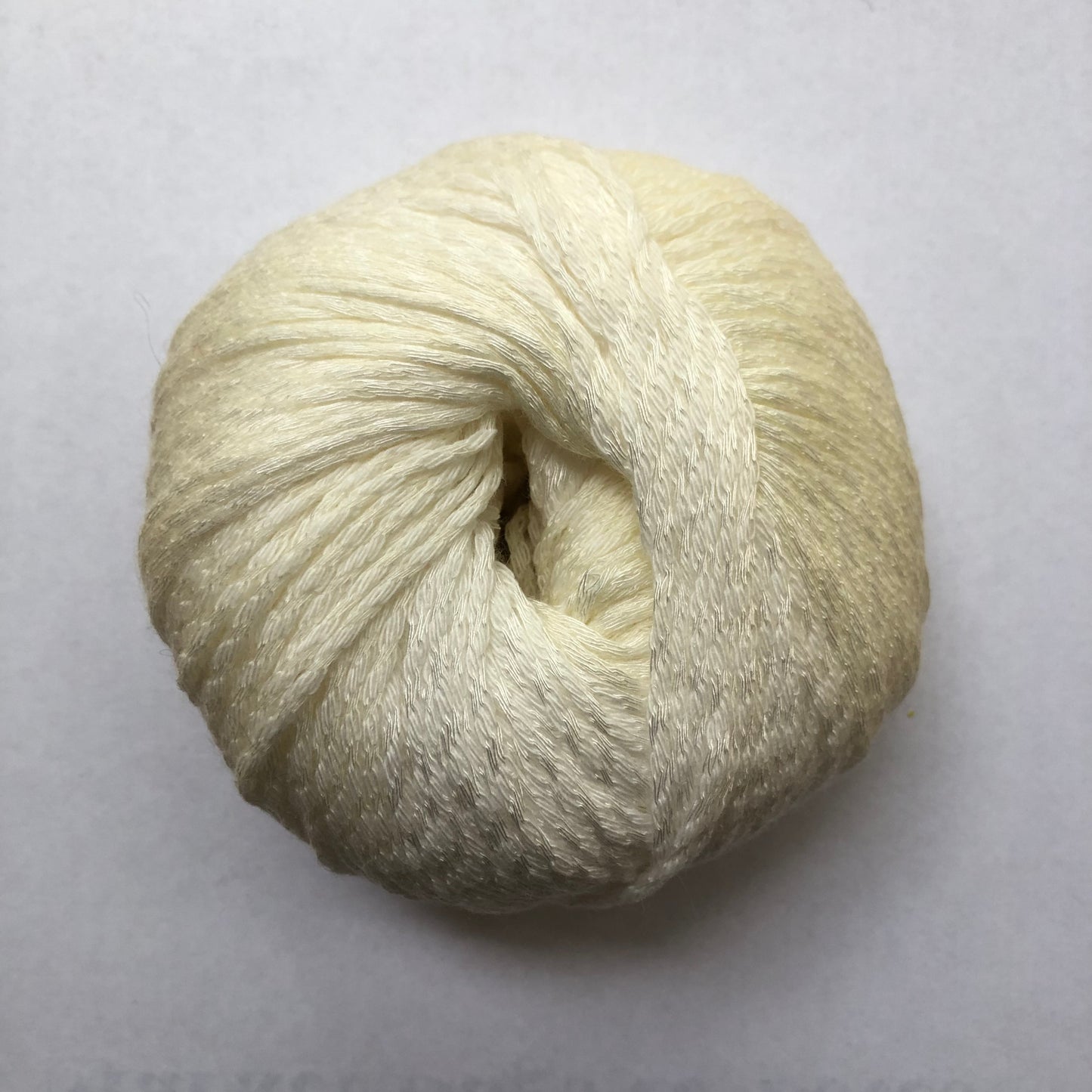 Ball of Lana Grossa Biosoja yarn in a cream/yellow color.