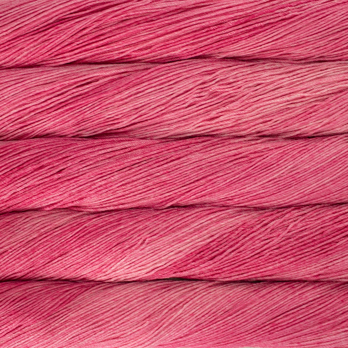 Skein of semisolid hot pink Malabrigo Arroyo yarn.